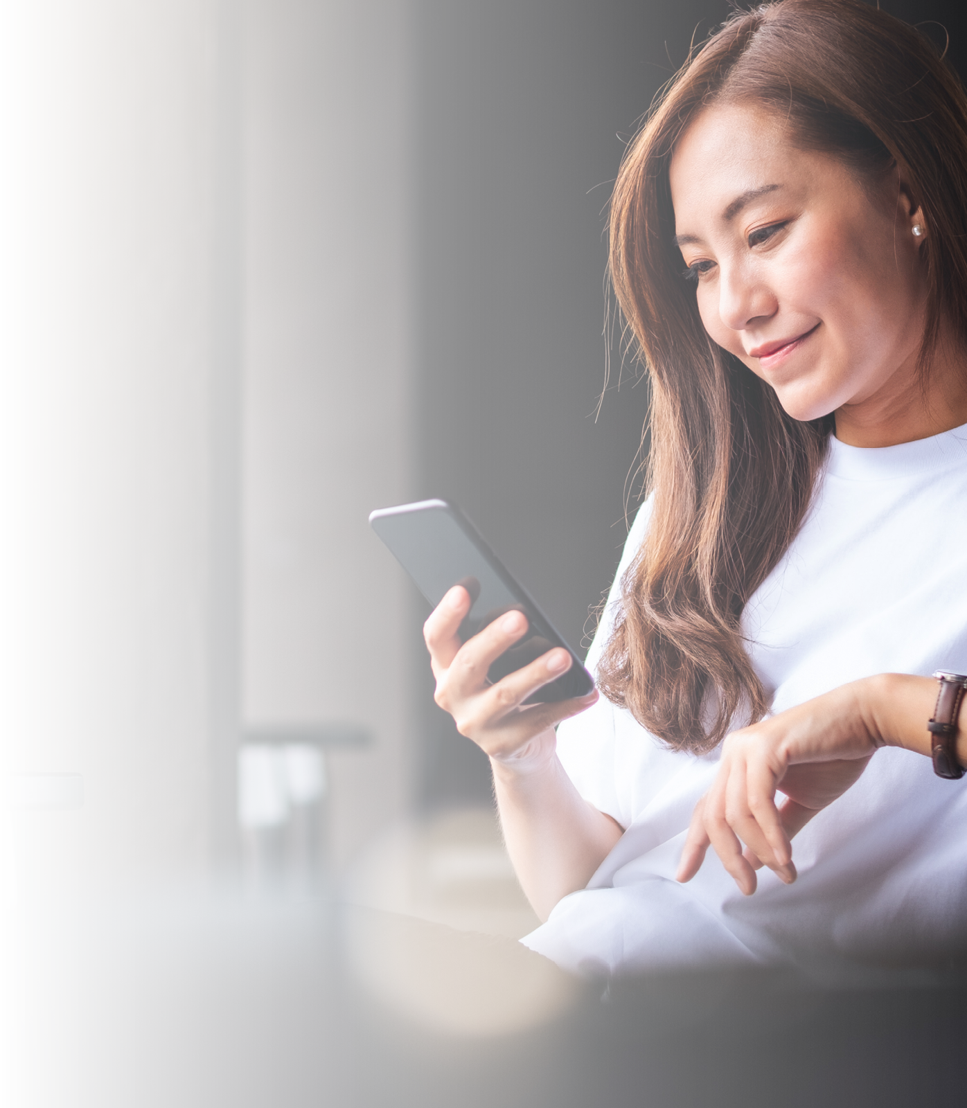 A beautiful young asian woman holding and using mobile phone