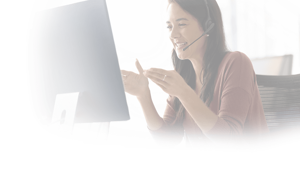 Positive Latin businesswoman in headphones talking on video call at monitor, speaking, laughing, moving hands. Cheerful online teacher giving business training, webinar
