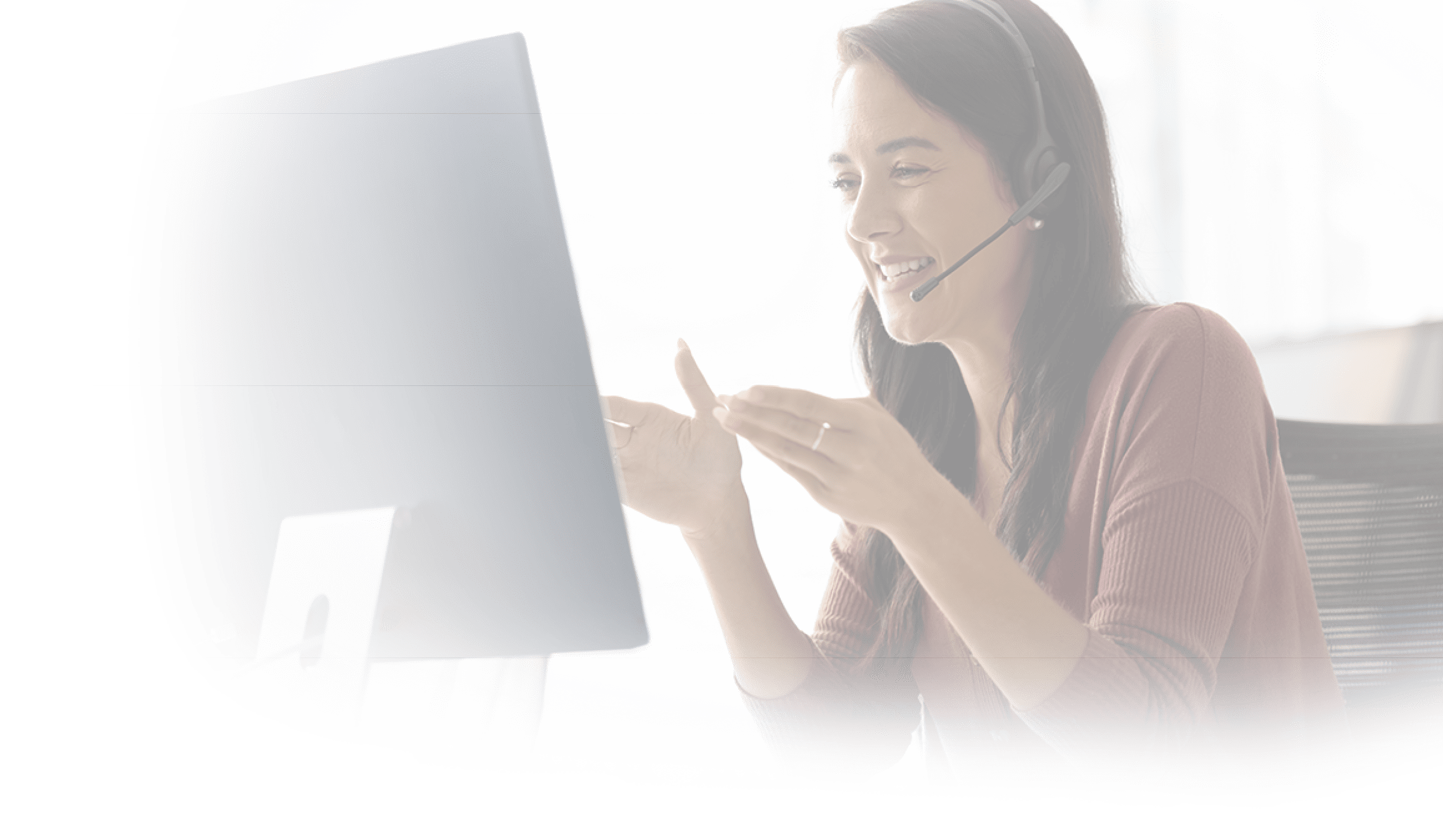 Positive Latin businesswoman in headphones talking on video call at monitor, speaking, laughing, moving hands. Cheerful online teacher giving business training, webinar