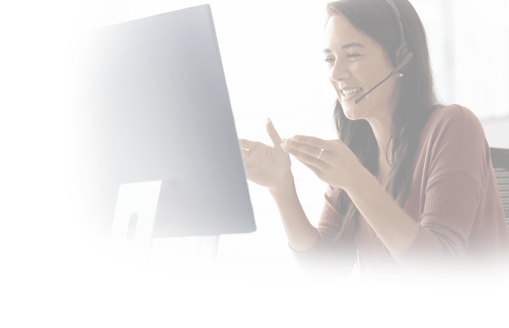 Positive Latin businesswoman in headphones talking on video call at monitor, speaking, laughing, moving hands. Cheerful online teacher giving business training, webinar